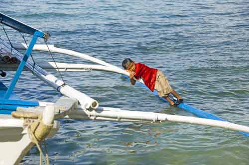 boy resting on boat-AsiaPhotoStock