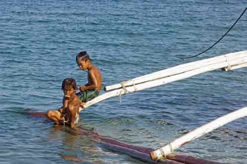 boys sit on outrigger-AsiaPhotoStock