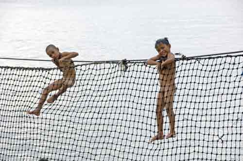 children on net fence-AsiaPhotoStock
