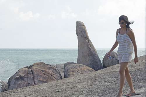 girl walks by rock-AsiaPhotoStock