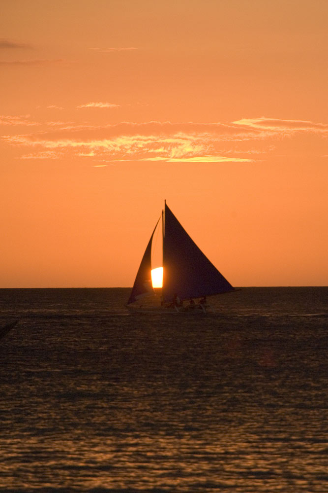 sun setting between sails-AsiaPhotoStock